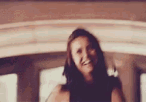 a woman is smiling and looking at the camera while sitting in a car .