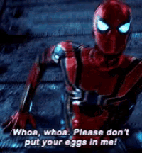 a spider man in a red suit is standing in the dark and talking to someone .