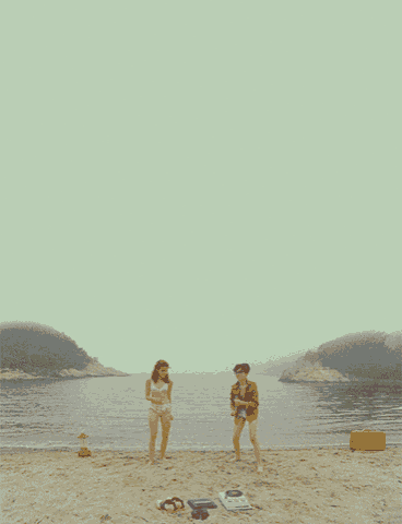 a man and a woman are dancing on a beach near the water