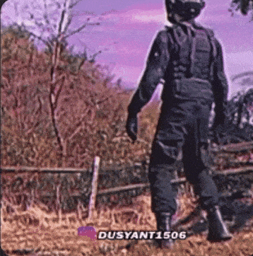 a person in a military uniform is standing in a field with a purple sky in the background .