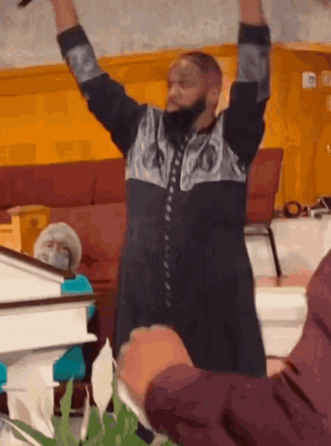 a man with his arms in the air is standing in a church .
