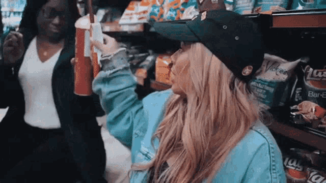 a woman wearing a black hat is standing next to another woman