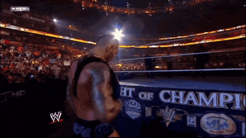 a man in a wrestling ring with a sign that says champions
