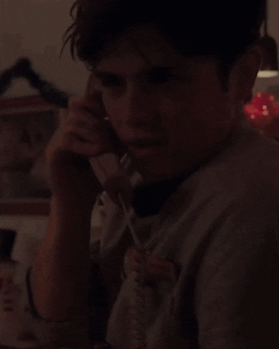 a young man is talking on a phone with a name tag that says ' chris ' on it