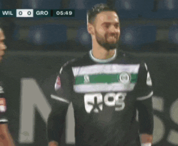two soccer players are shaking hands during a game and the score is wil 0-0 gro