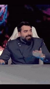 a man with a beard is sitting at a table in a chair .