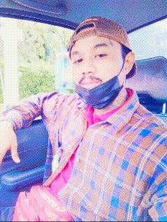 a man wearing a plaid shirt and a baseball cap is sitting in a car .