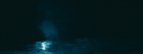 a statue of a woman sitting in front of a full moon surrounded by arrows
