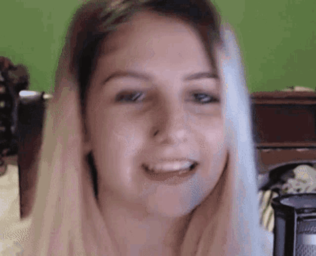 a close up of a woman 's face with a microphone in the background .