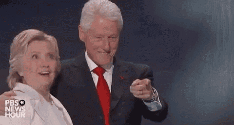 a man in a suit and tie is pointing at a woman in a white coat .