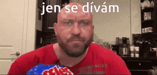 a bald man with a beard is eating a bag of chips with the words jen se divam above him