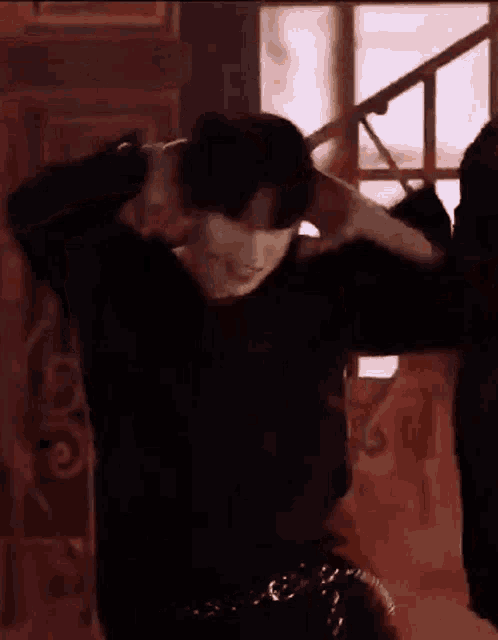 a man in a black shirt is holding his chest open .