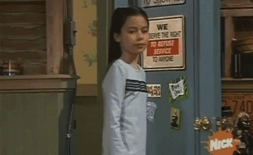 a girl standing in front of a fridge with a sign that says we serve the right to refuse service