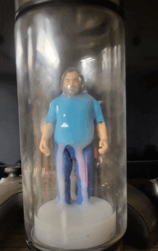 a plastic figurine of a man in a blue shirt and jeans