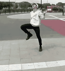 a man is jumping in the air while wearing a white hat and sunglasses .