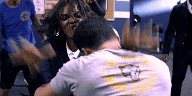 a man wearing a shirt that says ' lions ' on the back is fighting another man