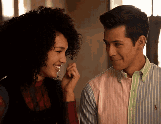 a man and woman are looking at each other and the man is wearing a polo shirt
