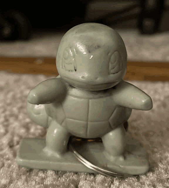 a squirtle toy is sitting on a carpeted floor