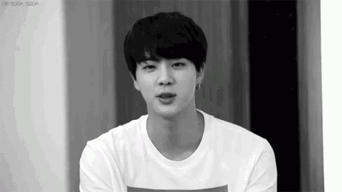 a black and white photo of a young man in a white t-shirt .