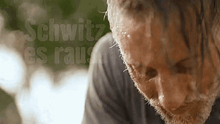 a close up of a man 's face with the words schwitz es rauh behind him