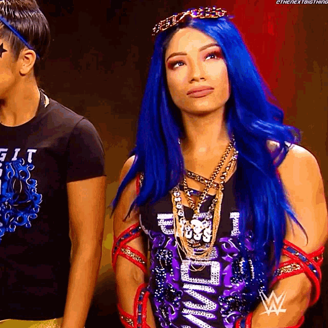 a woman with blue hair is wearing a crown and a shirt that says i am a king