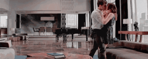 a man and a woman are kissing in a living room