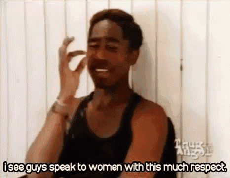 a man in a black tank top is making a funny face while talking to a woman .