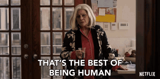 a woman holding a glass with the words that 's the best of being human