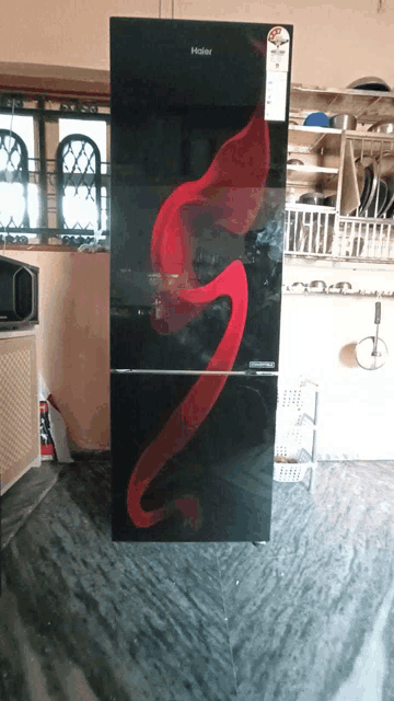 a black haier refrigerator with a red flamingo on the door