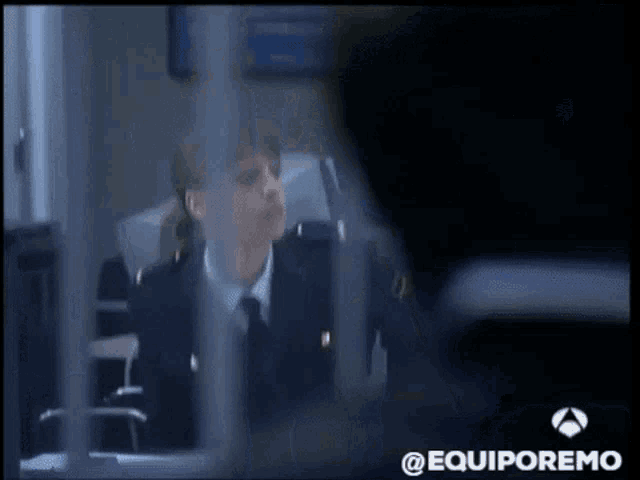 a woman in a suit and tie is talking to a man in a dark room with the words @equiporemo on the bottom right