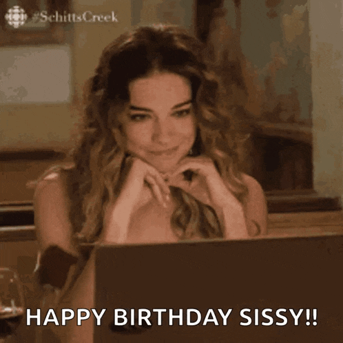 a woman is sitting in front of a laptop computer and says boop happy birthday sissy !