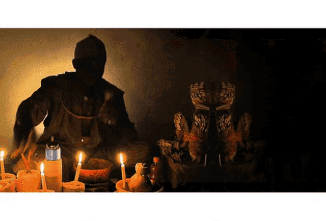 a man is sitting in front of a table with candles