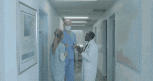a group of people are running down a hallway in a hospital .