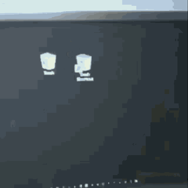 a computer monitor with a black screen and a few white icons