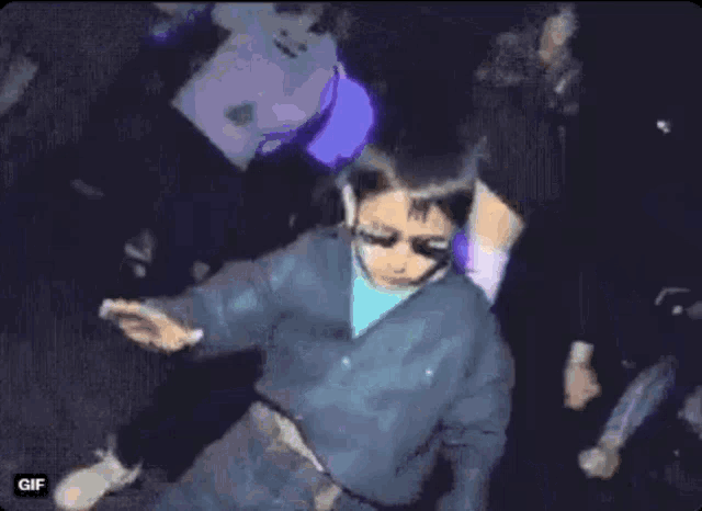 a little boy is dancing in front of a woman in a short skirt .