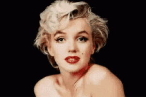 a close up of a woman 's face with blonde hair and red lipstick