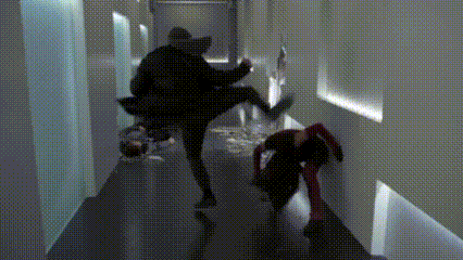 a group of people are walking down a hallway in a building