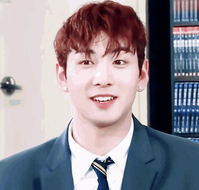 a man with red hair wearing a suit and tie