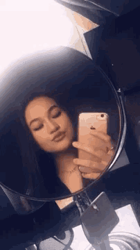 a girl is taking a selfie with her phone in a mirror
