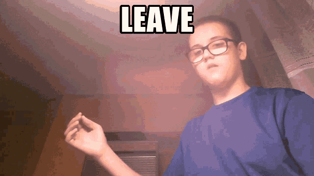 a man wearing glasses and a blue shirt with the words leave above him