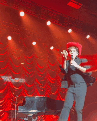 a man wearing a red hat holds a microphone in his hand