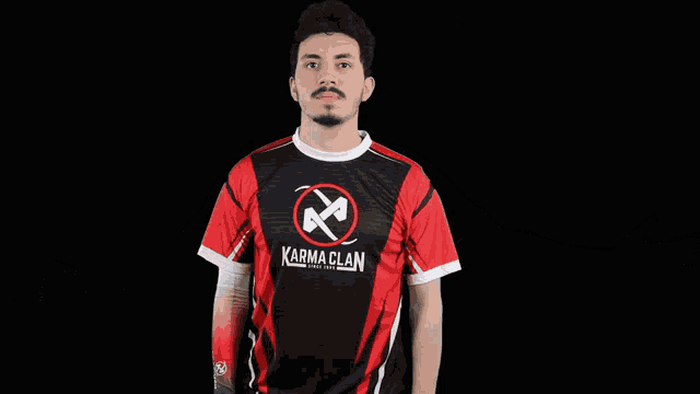a man is wearing a red and black shirt with the word karma clan on it