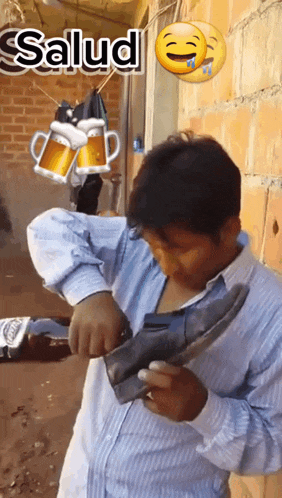 a man wearing a blue shirt is holding a pair of shoes with the word salud above him