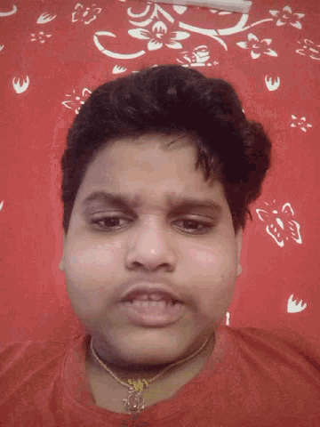 a man sticking his tongue out in front of a red wall