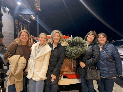 a group of women are posing for a picture in front of a truck that has the number 10 on the side