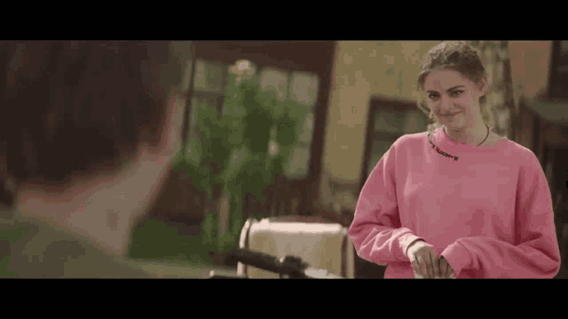 a girl in a pink sweater is standing next to a man in a green shirt .