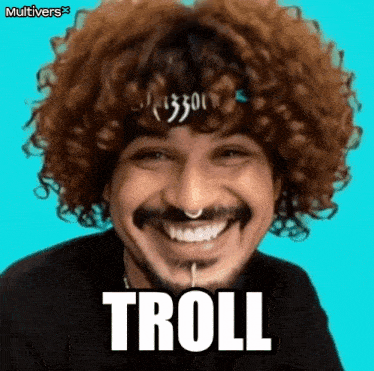 a man with curly hair and a nose ring is smiling and the word troll is on his face