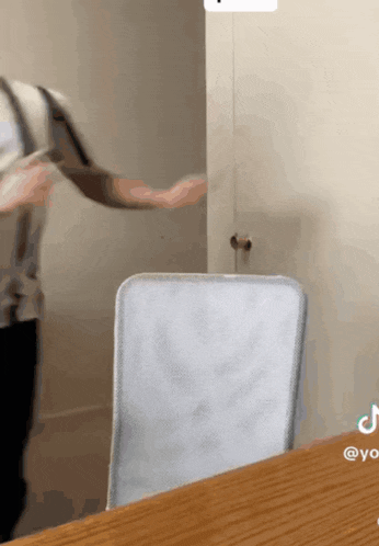 a person standing in front of a door with a chair in front of it