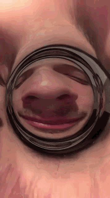 a close up of a person 's face looking through a magnifying glass