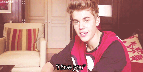a young man in a red shirt says " i love you " while sitting in a chair